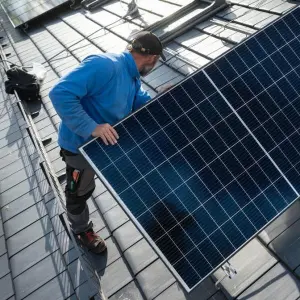 Mann installiert Solaranlage
