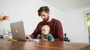 Mann mit Kleinkind im Homeoffice