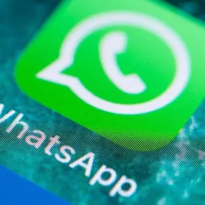 Das Logo von WhatsApp ist auf einem Handy-Display zu sehen