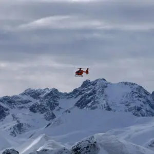 Hubschrauber fliegt über Schneeberge