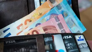 Banknoten und Bankkarten liegen in einer Geldbörse