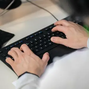 Mann arbeitet an einer Computer-Tastatur