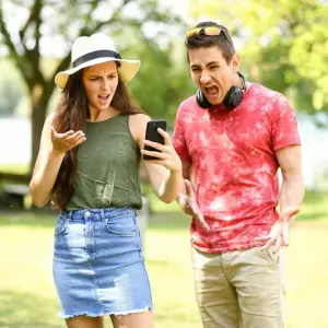 Paar schaut erschrocken auf Smartphone
