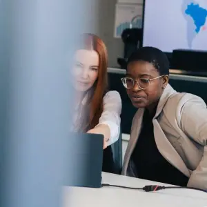 Zwei Frauen arbeiten zusammen an einem PC