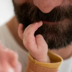 Baby fasst Vater in den Bart