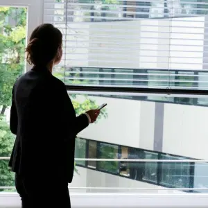 Eine Frau steht in einem Büro am Fenster