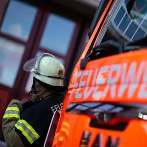 Feuerwehrmann steht neben einem Feuerwehrauto (Symbolbild)