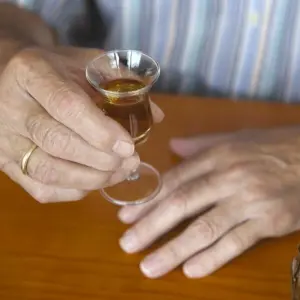 Ein Senior trinkt Schnaps
