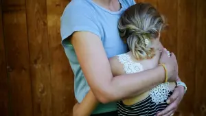 Ein Mädchen wird von seiner Mutter in den Arm genommen