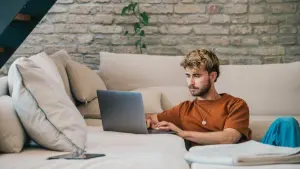 Ein junger Mann arbeitet am Laptop