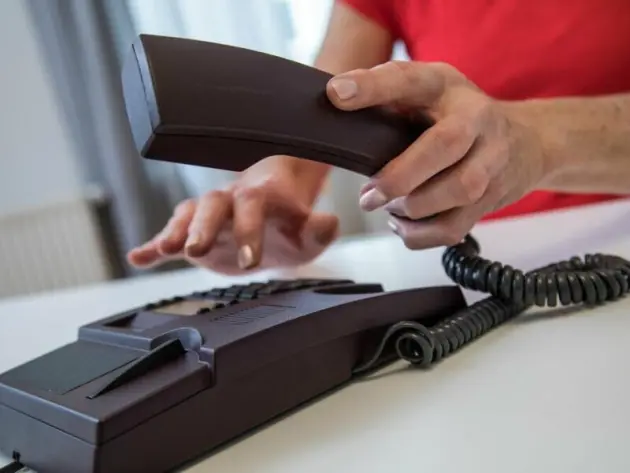 Eine Frau benutzt ein Festnetztelefon