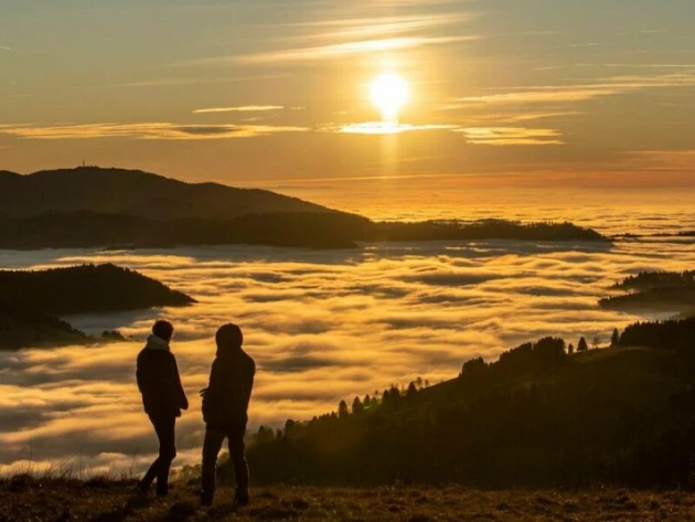 Zwei Spaziergänger betrachten den Sonnenuntergang