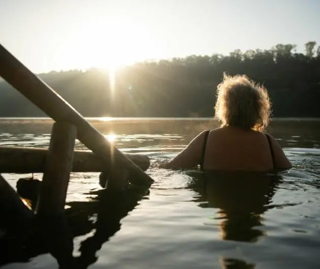Eine Frau geht im Kirchentellinsfurter Baggersee schwimmen