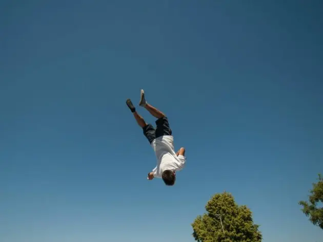 Ein Junge macht auf einem Trampolin einen Salto