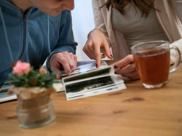 Ein Mann und eine Frau schauen sich Fotoalben an