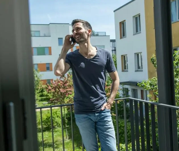 Ein Mann telefoniert auf einem Balkon