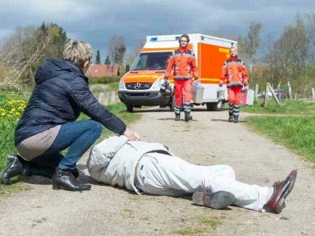 Eine Frau wartet auf einen Rettungswagen