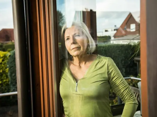 Eine Seniorin blickt aus dem Fenster