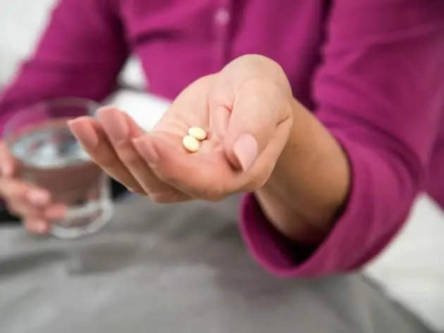 Frau mit Tabletten in der Hand