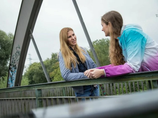 Zwei Frauen stehen auf einer Brücke