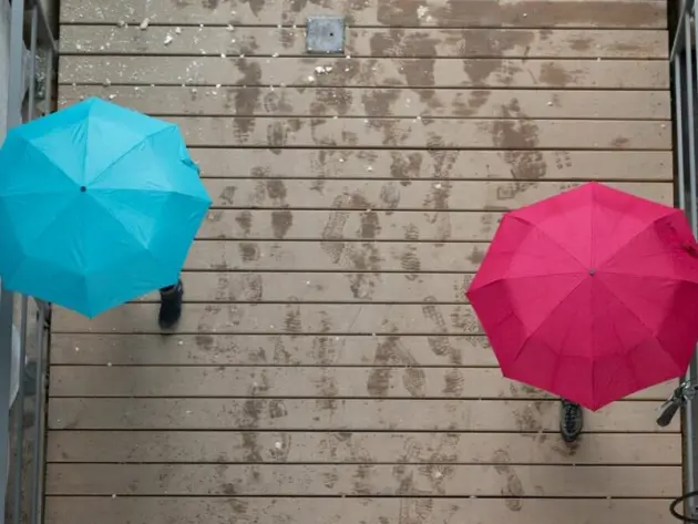 Passanten gehen unter Regenschirmen spazieren