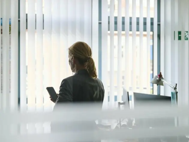 Frau mit Smartphone im Büro